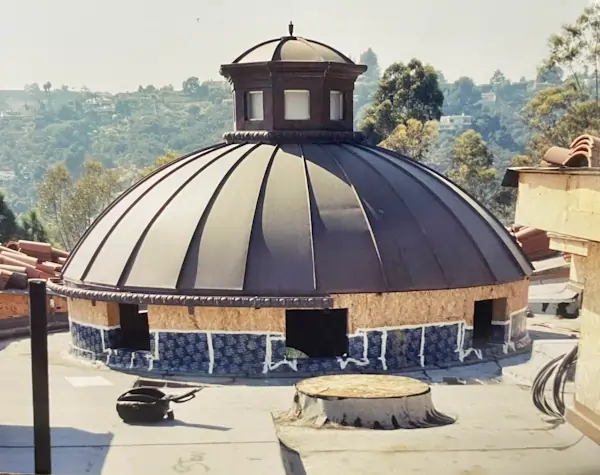 A circular gray metal roof on top of a building.