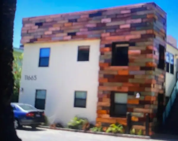 A small two floor building with a copper wall in a brick pattern.