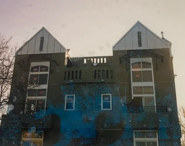 A two floor building with a white metal roof.