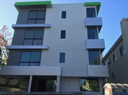 Green seamless fascia at the top of an aprtment building.