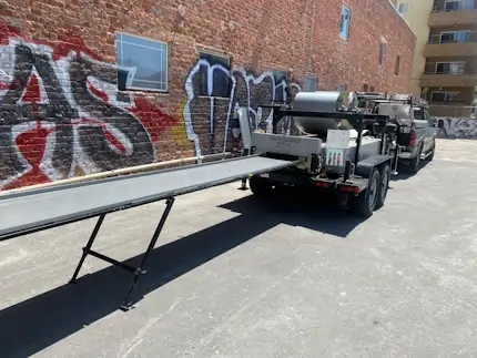 A pickup truck towing a sheet metal fabrication machine.