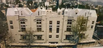 A large multi story apartment building with a white metal roof.